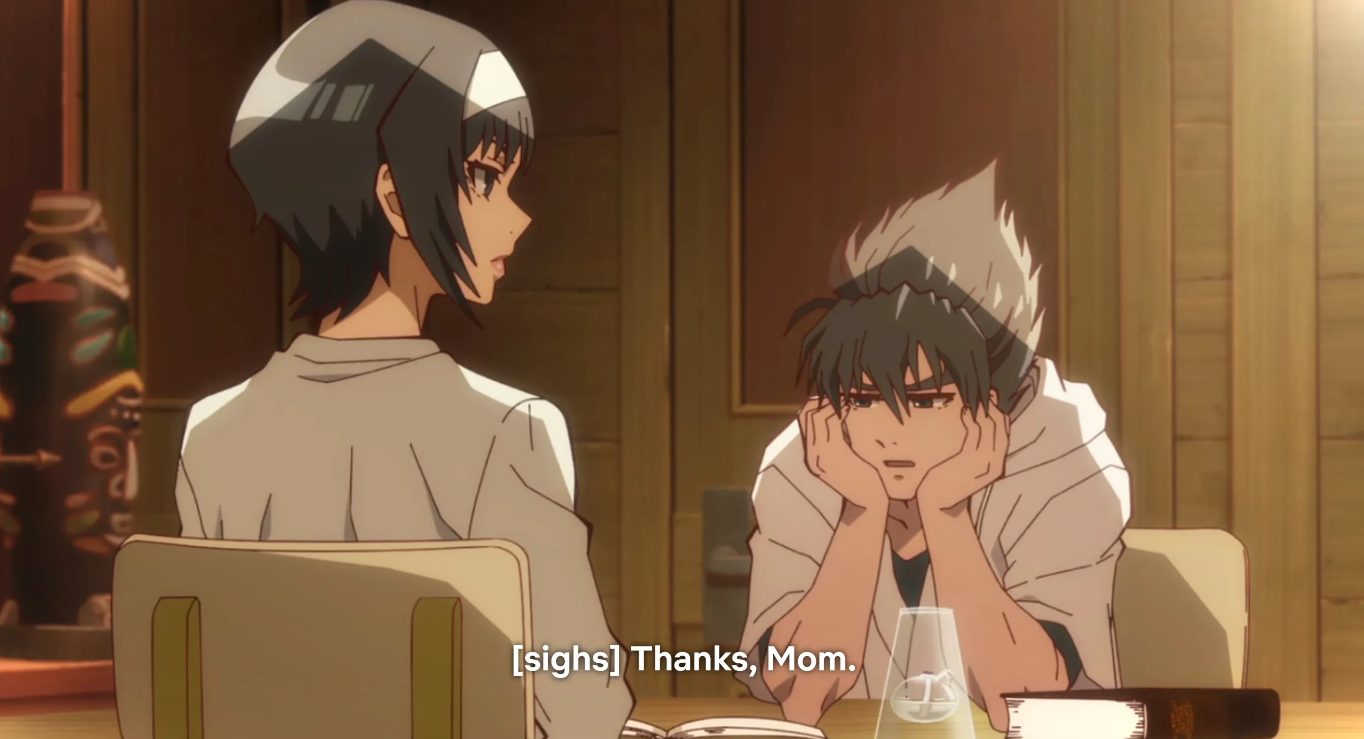 Jin y Jun sentados en una mesa.  Jin apoya su rostro con tristeza en sus manos.  El texto del subtítulo dice: [suspiros] Gracias, mamá.