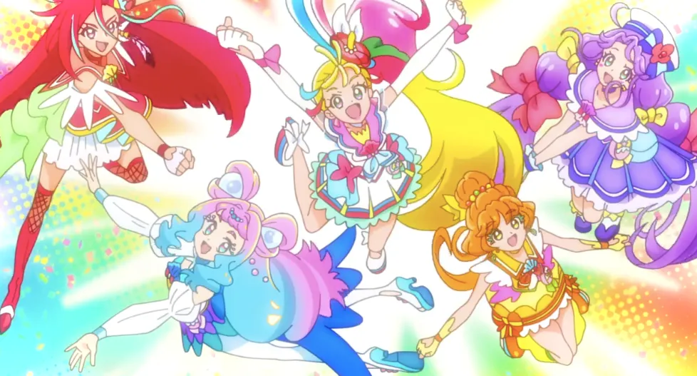 Foto grupal del equipo de Tropical PreCure, transformados en sus versiones de chicas mágicas, saltando hacia la cámara.