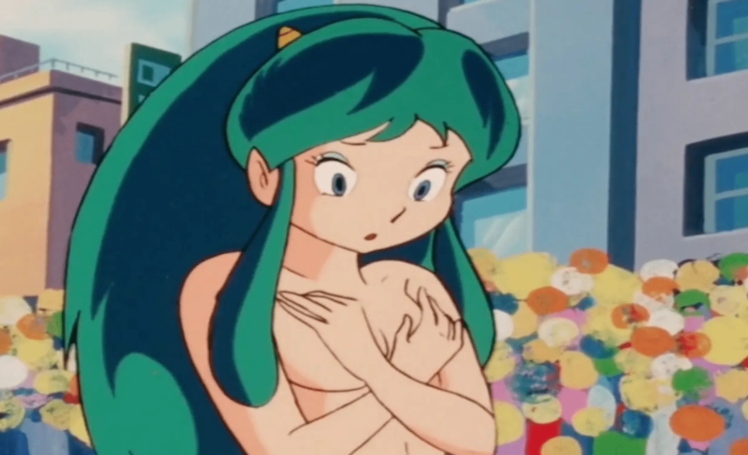 Lum en 1981, mirando recatadamente su pecho desnudo y cruzándose de brazos para cubrirlo.