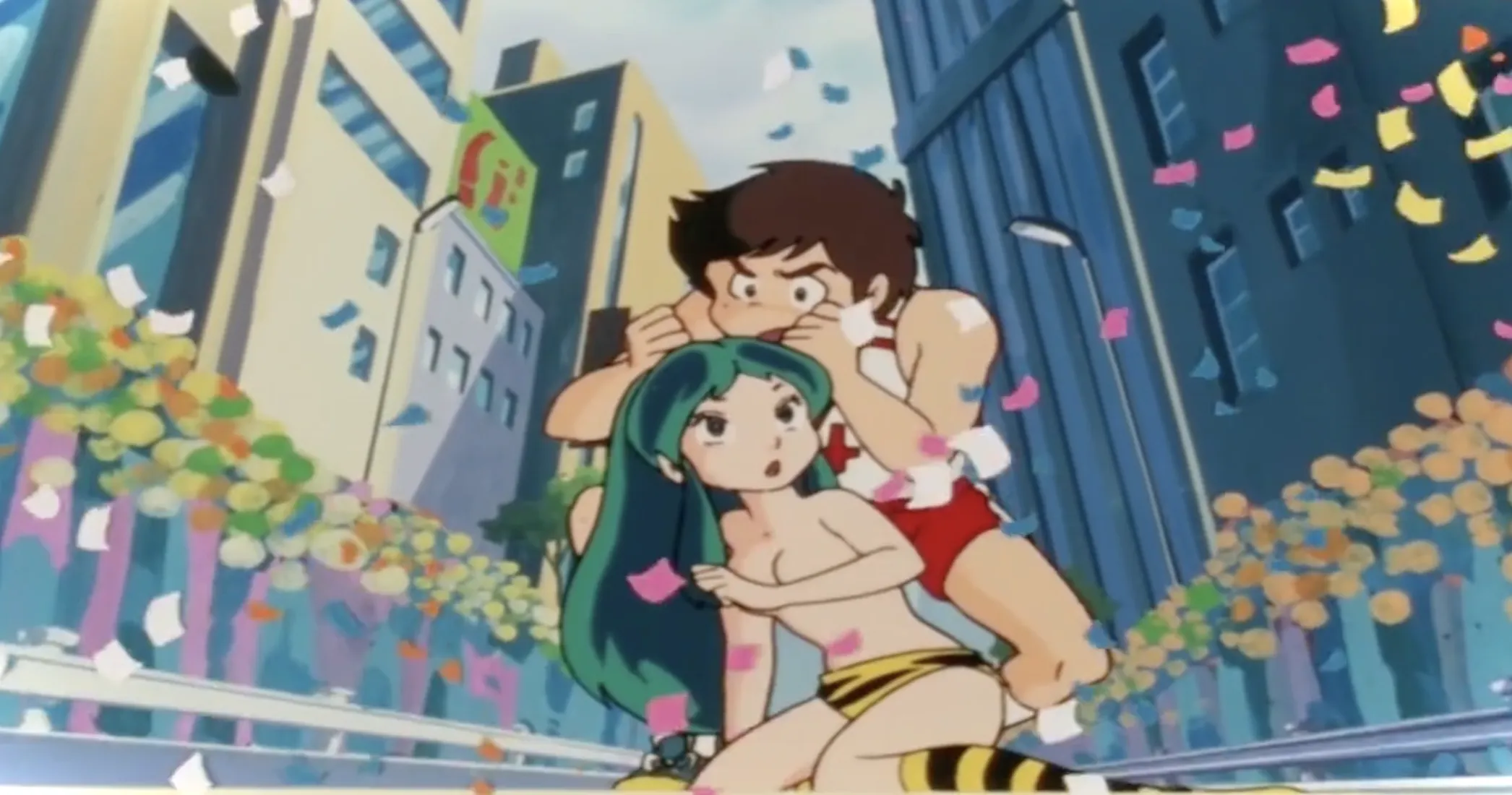 Lum pierde el juego contra Ataru en medio de una calle de la ciudad.  Él se para encima de ella agarrando sus cuernos mientras ella se sienta, con un brazo cubriendo su pecho desnudo.