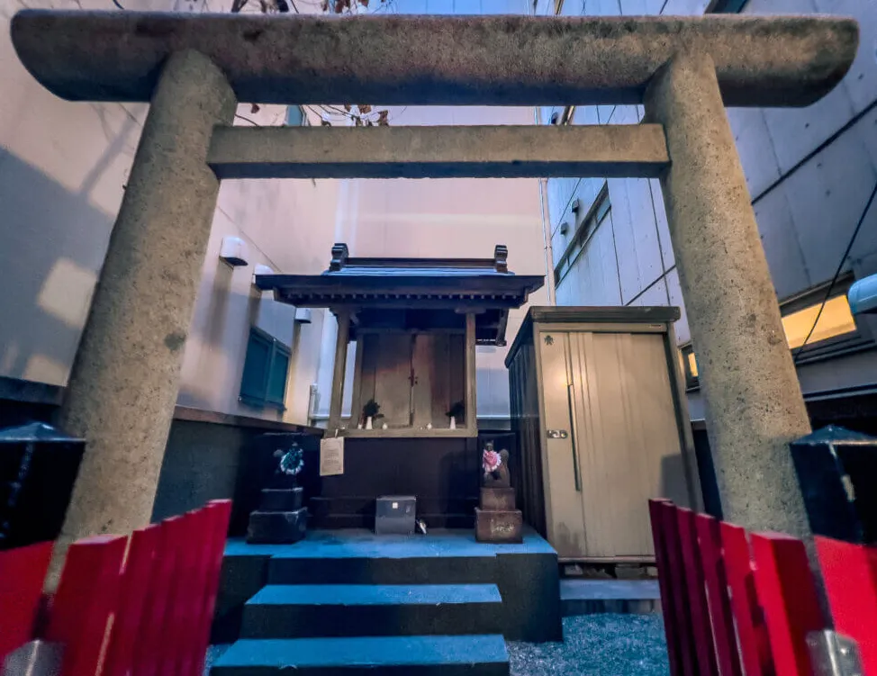 Escondido entre dos grandes edificios, un pequeño santuario japonés se encuentra cómodamente ubicado entre ellos.