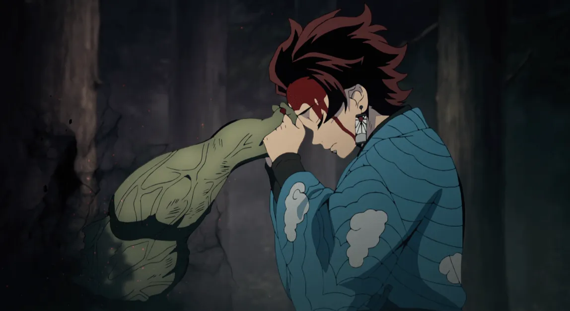 Tanjiro toca con su frente la mano de un demonio.